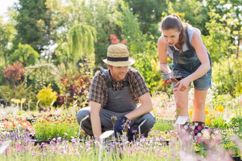 Gardener using pruning tools in a well-maintained garden